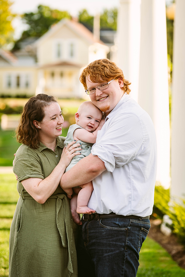 Candid moment of a couple holding their baby, during a family photoshoot.