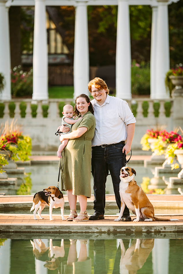 A family of three with two dogs enjoying a photography session at Lakeside Park, surrounded by natural scenery and evening light.