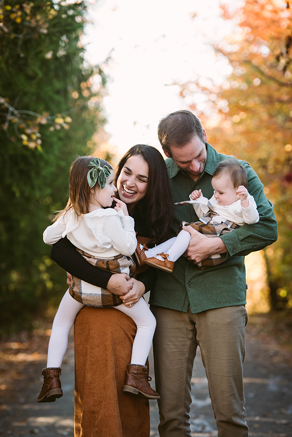 Candid family of four sharing a joyful moment during a relaxed Fort Wayne photo session in natural evening light